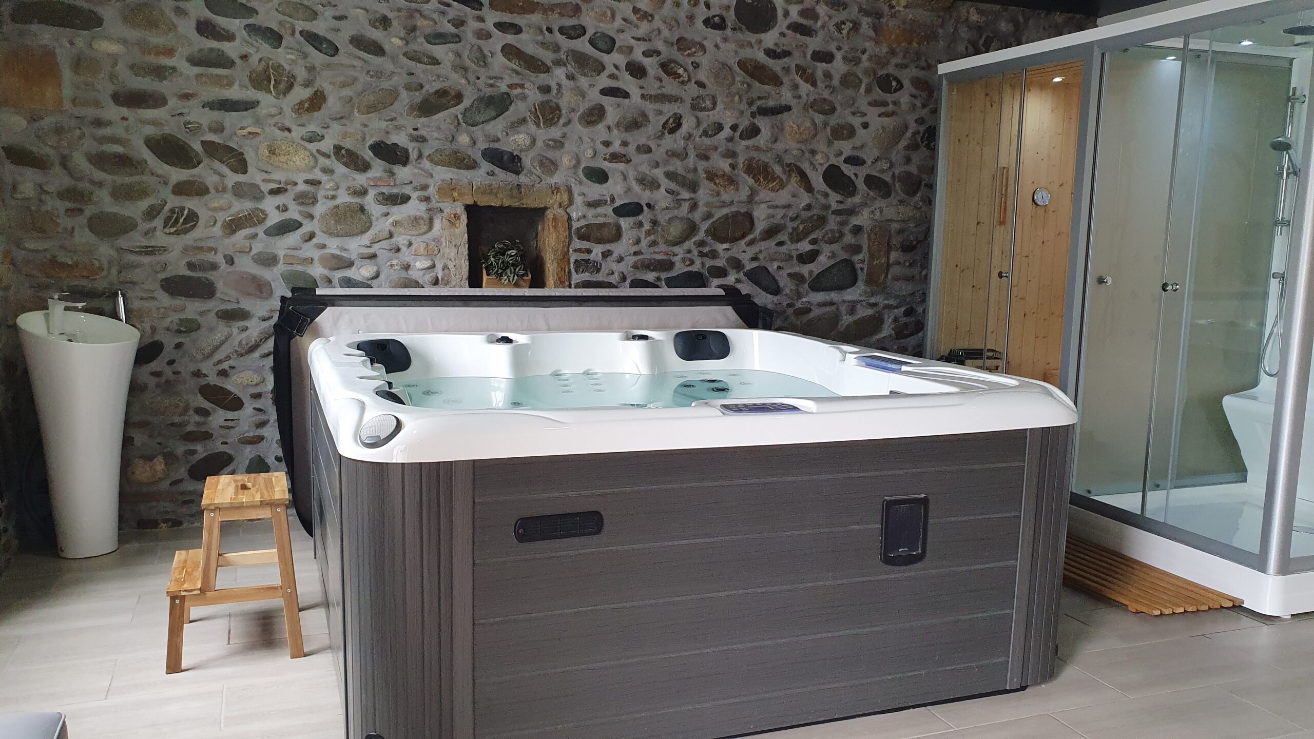 El jacuzzi del SPA junto al muro de piedra