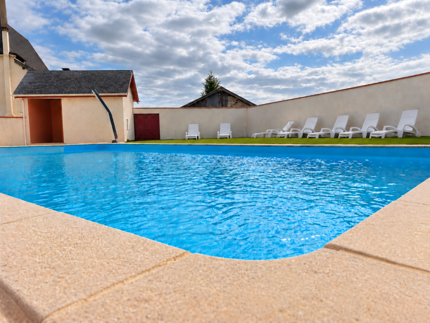 La piscine extérieure du château et sa plage dallée